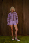 Front view of Alli Marye purple smocked cotton bloomers styled with a lilac striped cardigan.